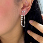 Woman wearing elongated dangle diamond earrings (etsy image id: 6698294958)