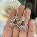 Woman holding Yellow and White gold three row pear shape drop earrings. (etsy image id: 6710356020)