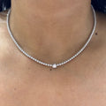 Woman wearing a diamond tennis necklace with larger carat stone in the center. (etsy image id: 6712827626)