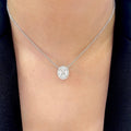 Woman wearing a white gold diamond pendant in a halo setting (etsy image id: 6722733936)