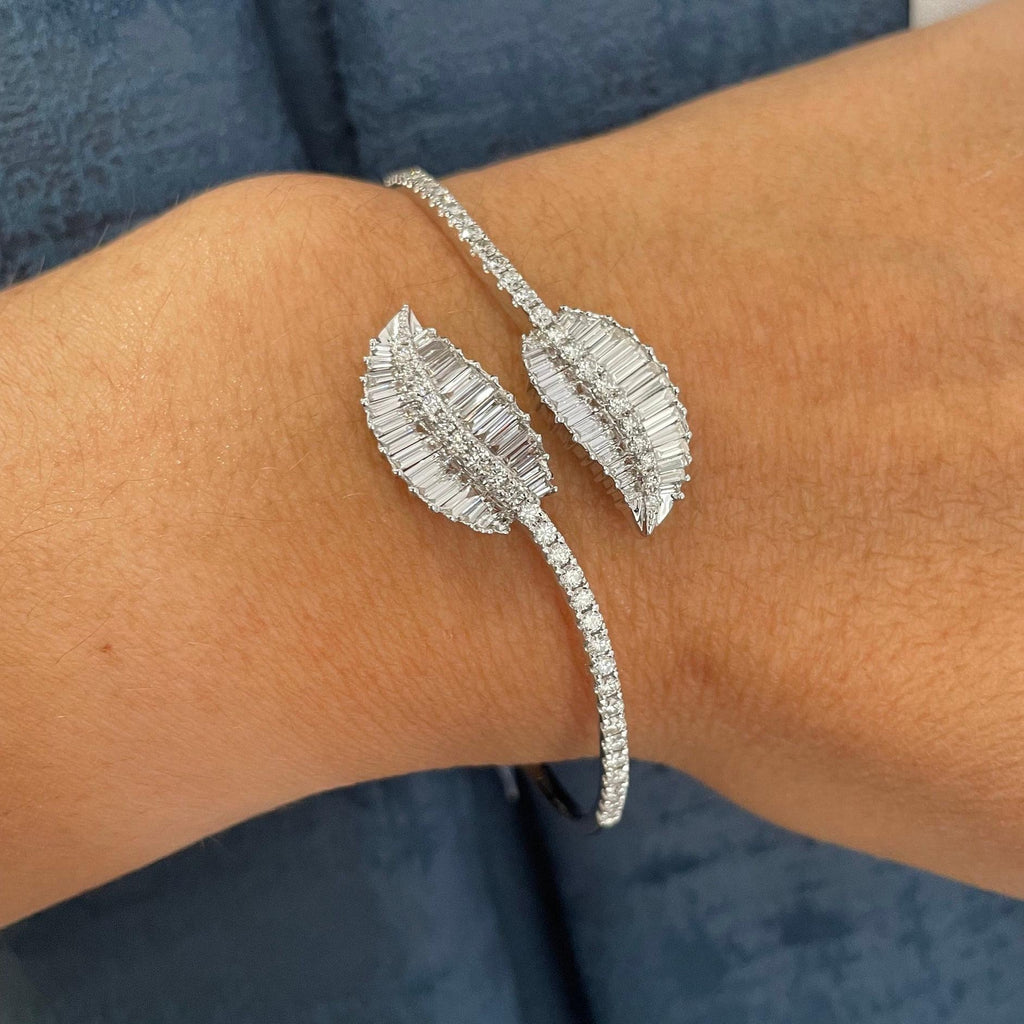 Woman wearing white gold bangle with round diamonds on the bracelet and baguette and round diamonds on the leaf design at the ends. (etsy image id: 6725624486)
