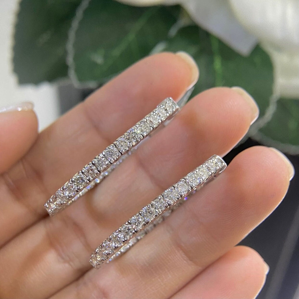 Woman holding 14k white gold oval shape inside out diamonds hoop earrings. (etsy image id: 6730878384)