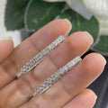 Woman holding 14k white gold oval shape inside out diamonds hoop earrings. (etsy image id: 6730878384)
