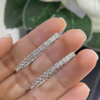 Woman holding 14k white gold oval shape inside out diamonds hoop earrings. (etsy image id: 6730878384)