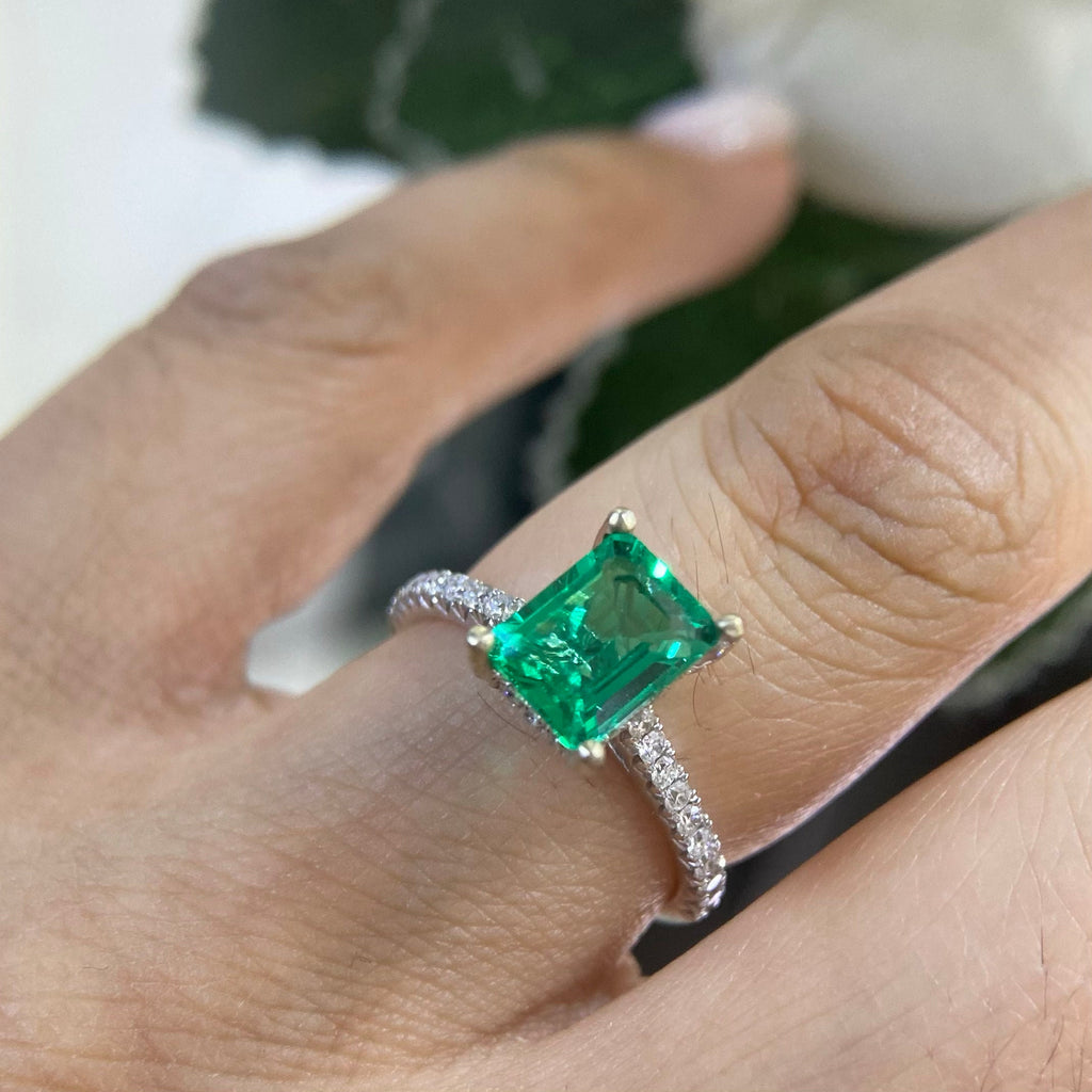 Woman wearing an emerald cut Green Compressed Emerald ring with diamonds on the band. (etsy image id: 6730942208)