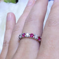 Woman wearing white gold band ring with alternating  round cut ruby and round cut diamonds (etsy image id: 6746220348)