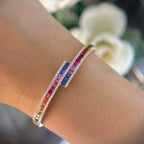 Woman wearing multi-colored princess cut sapphire bangle with round cut diamonds. (etsy image id: 6760969471)