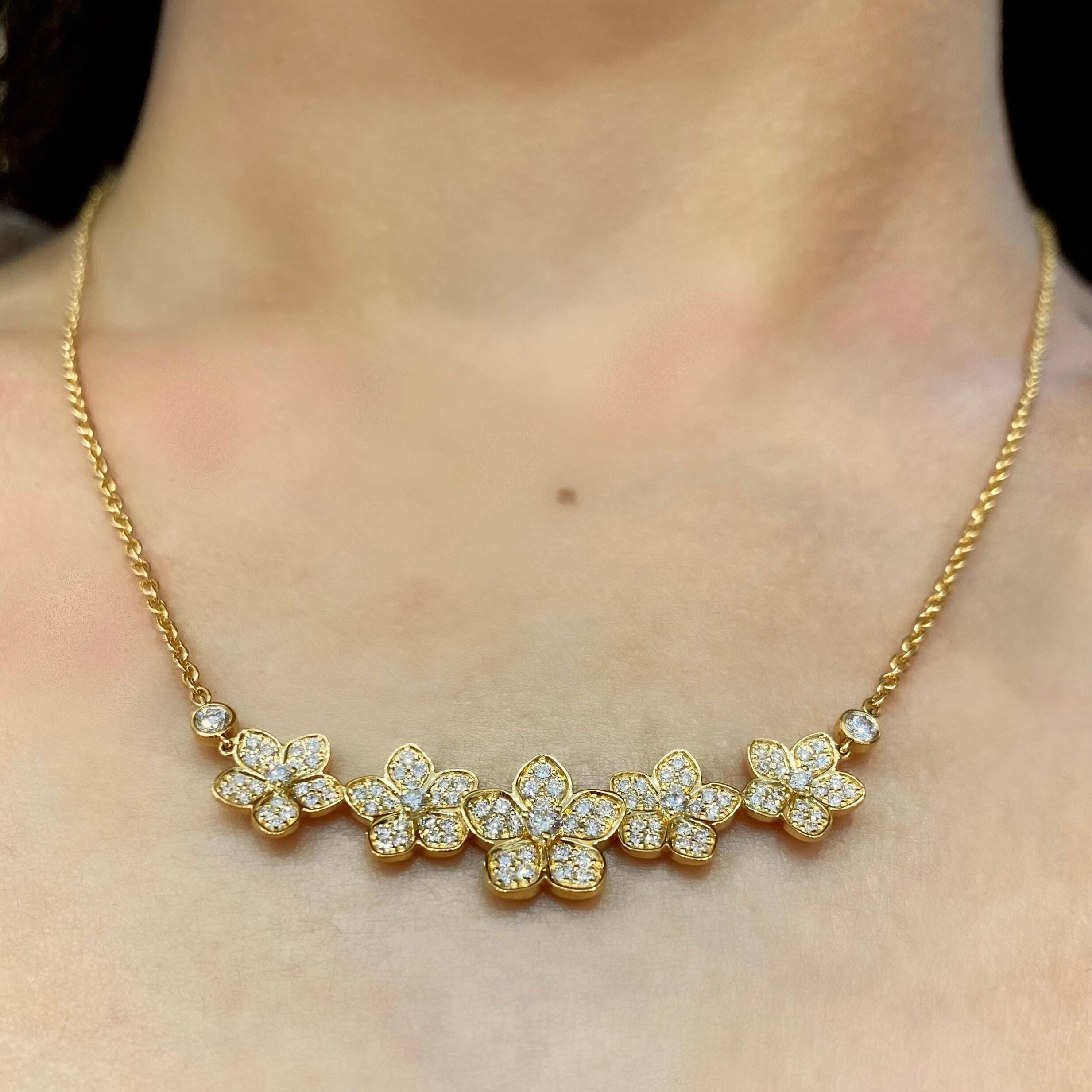 Woman wearing a yellow gold necklace with 5 star flower shape smile diamond necklace (etsy image id: 6767985736)