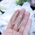 Woman holding Rose Gold Hoop Earrings with inside out diamonds (etsy image id: 6768149102)