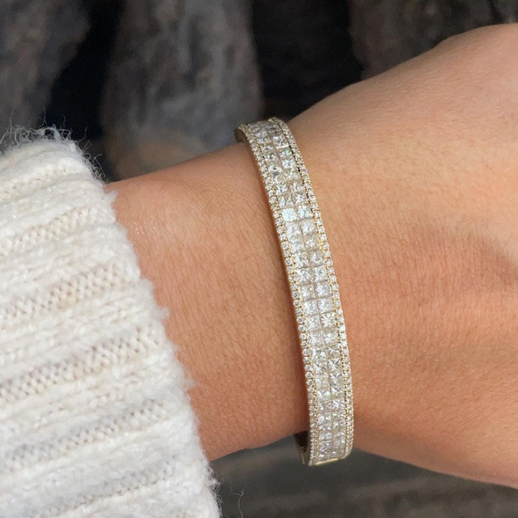 Woman wearing a gold bangle with princess and round cut diamonds (etsy image id: 6770736537)
