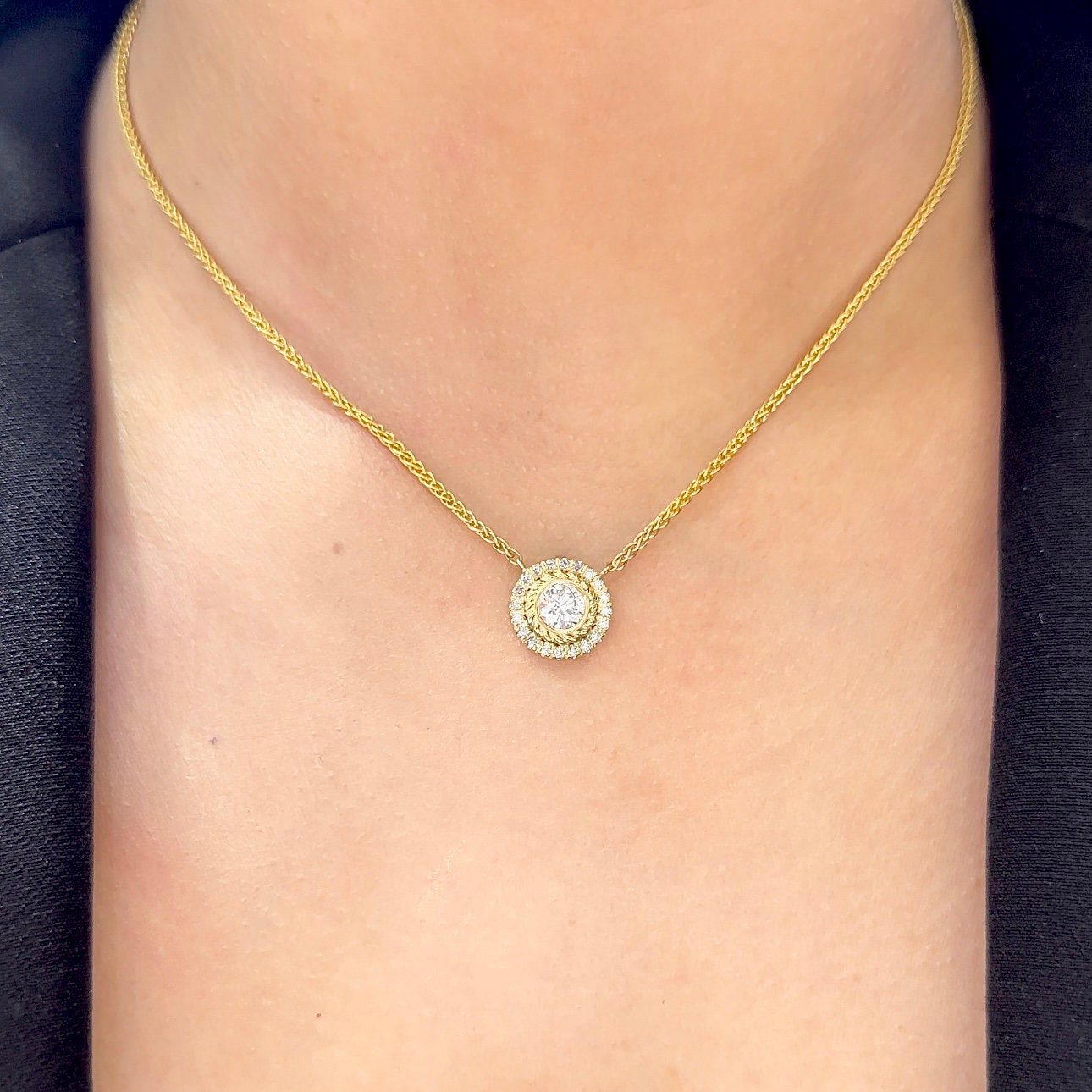 Woman wearing yellow gold chain with center pendant featuring single diamond surrounded by a halo of diamonds (etsy image id: 6770904385)