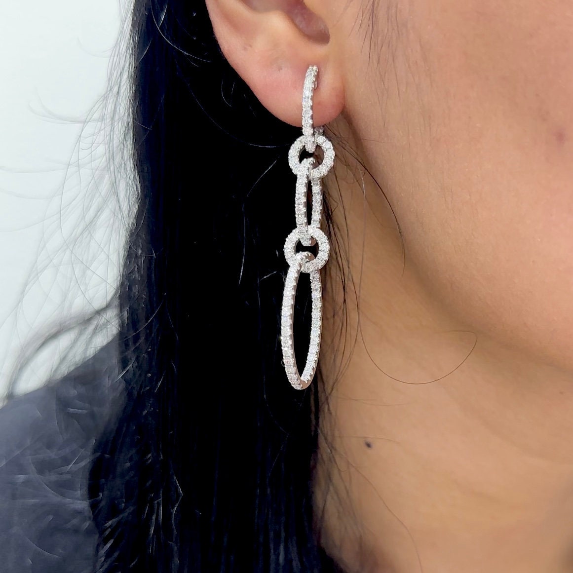 Woman wearing dangling 5 circle diamond earring (etsy image id: 6771006249)