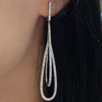 Woman wearing double tear drop elongated diamond earrings. (etsy image id: 6788592361)