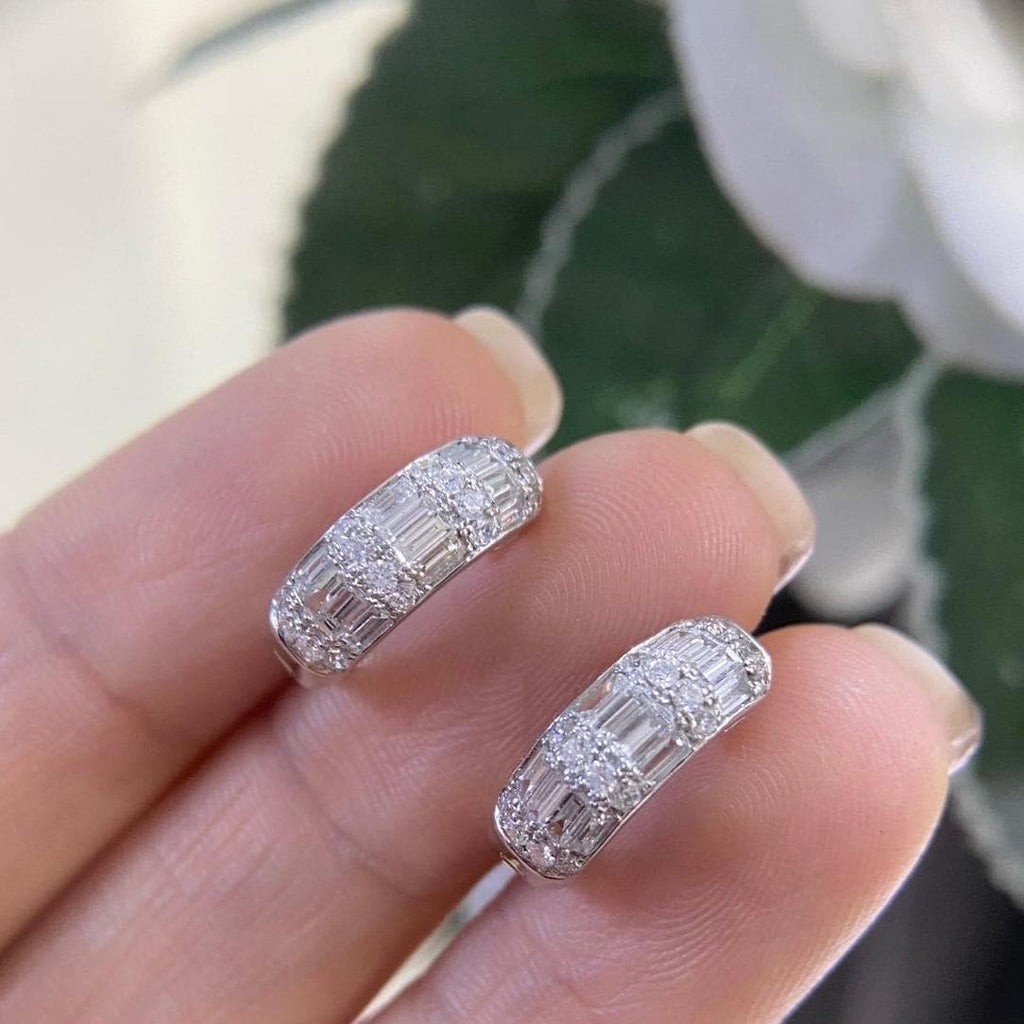 Woman holding white gold small huggie hoop earrings with baguette and round cut diamonds (etsy image id: 6789055015)