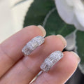 Woman holding white gold small huggie hoop earrings with baguette and round cut diamonds (etsy image id: 6789055015)