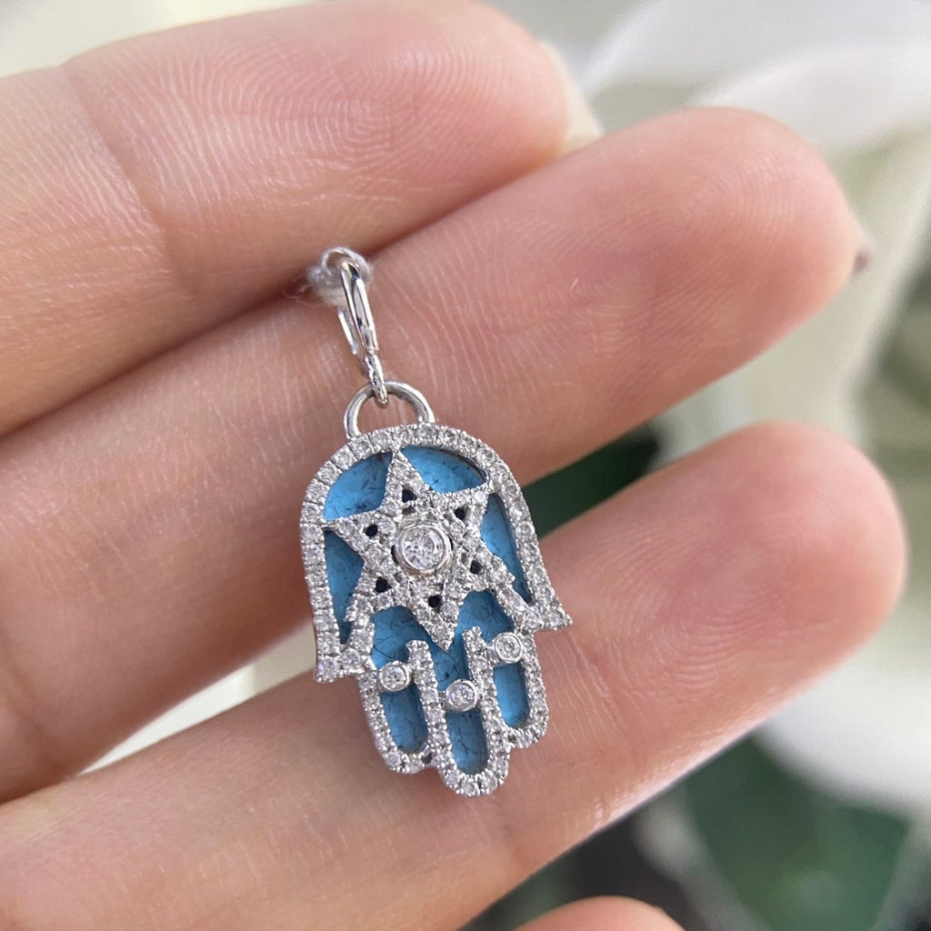 Woman holding white gold diamond hamsa with star of david with a sky blue backround (etsy image id: 6813395075)