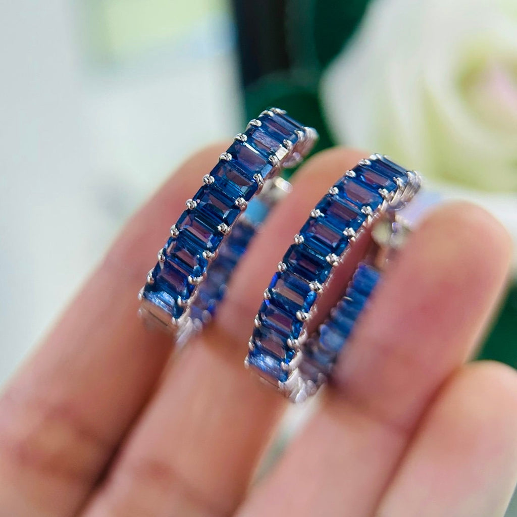 May include: Two silver hoop earrings with blue baguette shaped gemstones (etsy image id: 6831697510)