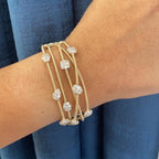 Woman wearing a yellow gold 5 row coil bracelet with clusters of diamonds. (etsy image id: 6845749612)