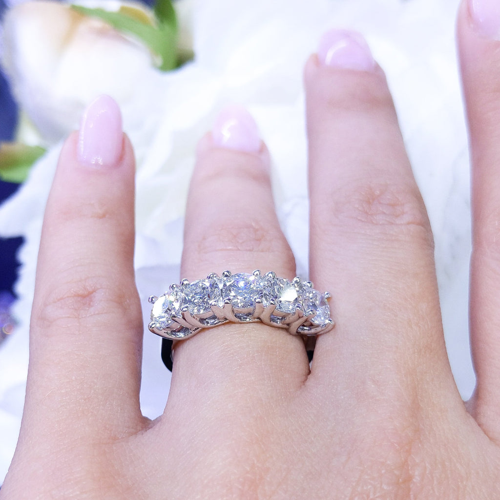 A white gold band ring with five large, clear, round-shaped diamonds. The gemstones are set in a prong setting. (etsy image id: 6876891503)