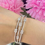 May include: A silver bangle bracelet with multiple rows of pave set diamonds. The bracelet features square shaped diamond accents. (etsy image id: 6881600837)