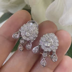 White Gold Hanging Earrings with a Oval Cut Center Stone Diamond and Surrounding Round Cut Diamonds