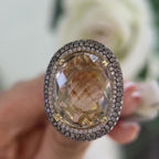 14Kt Yellow Gold Ring with an oval cut 19.32ct smoky topaz  0.31ct total in round cut white diamonds ,and 1.22ct total in champagne diamonds